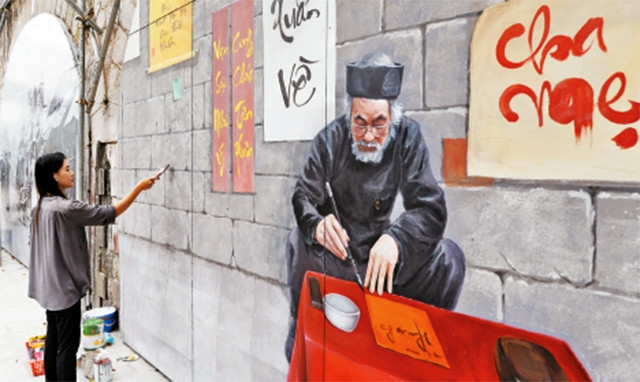 Họa sĩ vẽ những bức bích họa lớn lên vòm cầu trên phố Phùng Hưng.