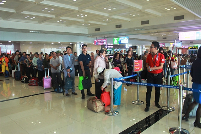 Hành khách làm thủ tục soi chiếu an ninh tại nhà ga T1 Cảng hàng không quốc tế Nội Bài (Hà Nội).