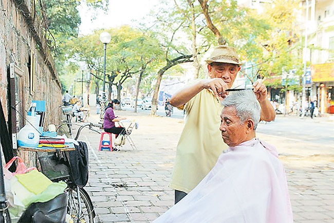 Tiệm cắt tóc tại vỉa hè phố Văn Miếu. Ảnh: NHUNG HÀ