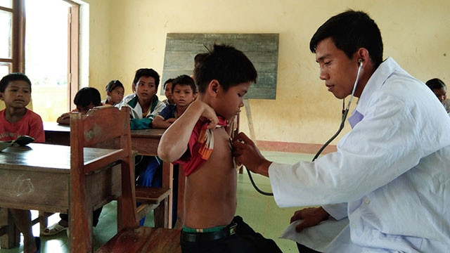 Anh Hồ Văn Thon kiểm tra sức khỏe cho các em học sinh thuộc điểm trường Pa Lin.