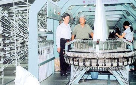 Chủ nhiệm HTX Song Long Nguyễn Gia Thọ (người thứ hai từ trái sang) hướng dẫn khách tham quan dây chuyền sản xuất.