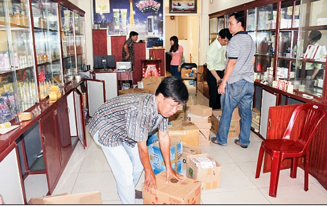 Lực lượng chức năng phát hiện, thu giữ tang vật là mỹ phẩm nhập lậu nghi nhái nhãn hiệu tại một cửa hàng ở quận 1, TP Hồ Chí Minh vào ngày 9-7-2015.