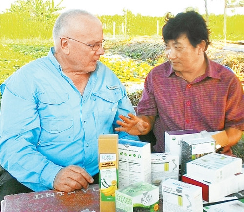 Ông Võ Minh Khải (người bên phải) giới thiệu các sản phẩm gạo sạch của nông trại Viễn Phú với chuyên gia đến từ Ô-xtrây-li-a.