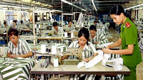 Cán bộ quản giáo hướng dẫn phạm nhân học nghề may công nghiệp tại Trại giam Thủ Đức, Bình Thuận. Ảnh: DOÃN TUẤN