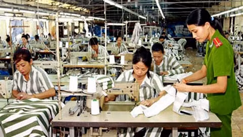 Cán bộ quản giáo hướng dẫn phạm nhân học nghề may công nghiệp tại Trại giam Thủ Đức, Bình Thuận. Ảnh: DOÃN TUẤN