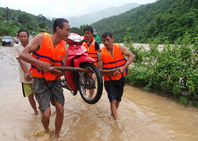 Nước lũ gây ngập nhiều tuyến đường ở huyện Kỳ Sơn, Nghệ An. Người dân di chuyển phương tiện, đồ đạc ra khỏi vùng ngập lụt. Ảnh Báo Nghệ An