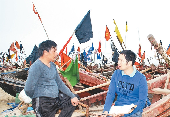Nhà báo Dương Đình Tường (bên phải) hỏi chuyện ngư dân Quảng Ngãi về việc hỗ trợ bám biển. 
