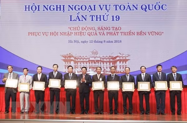 Phó Thủ tướng, Bộ trưởng Bộ Ngoại giao Phạm Bình Minh trao Kỷ niệm chương Vì sự nghiệp Ngoại giao Việt Nam cho các lãnh đạo tỉnh, thành phố. Ảnh: TTXVN