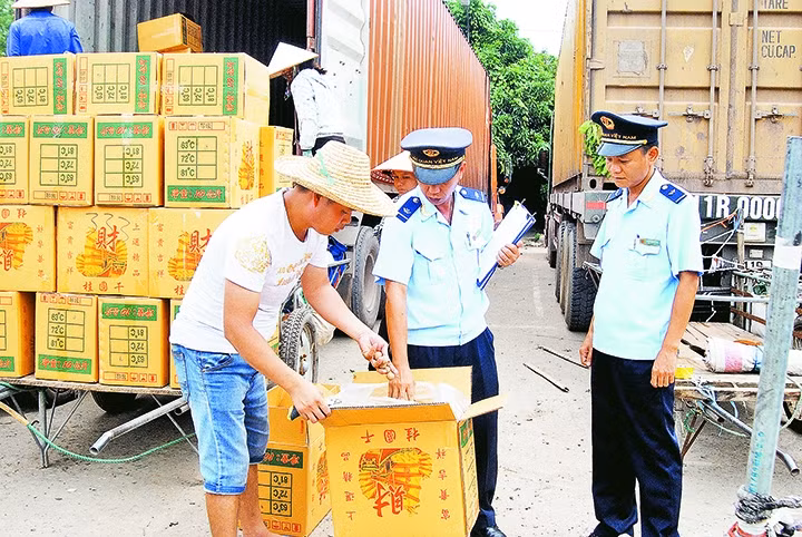 Cán bộ Chi cục Hải quan Cửa khẩu Móng Cái kiểm tra hàng nhập khẩu. Ảnh: QUANG THỌ