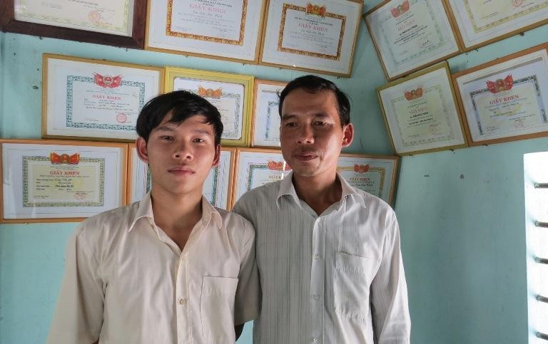 Thịnh và bố trong căn phòng treo nhiều giấy khen