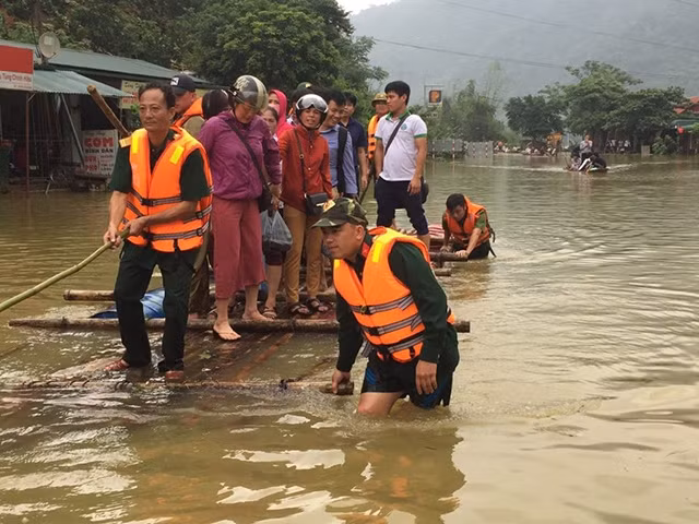Các chiến sĩ Ban Chỉ huy quân sự huyện Mai Châu (Hòa Bình) giúp người dân di chuyển đến nơi an toàn. Ảnh: TRẦN HẢO