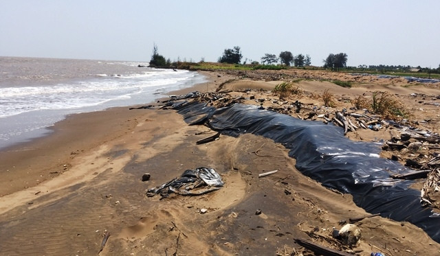 Người dân dùng cát làm bờ đê để ngăn sạt lở.