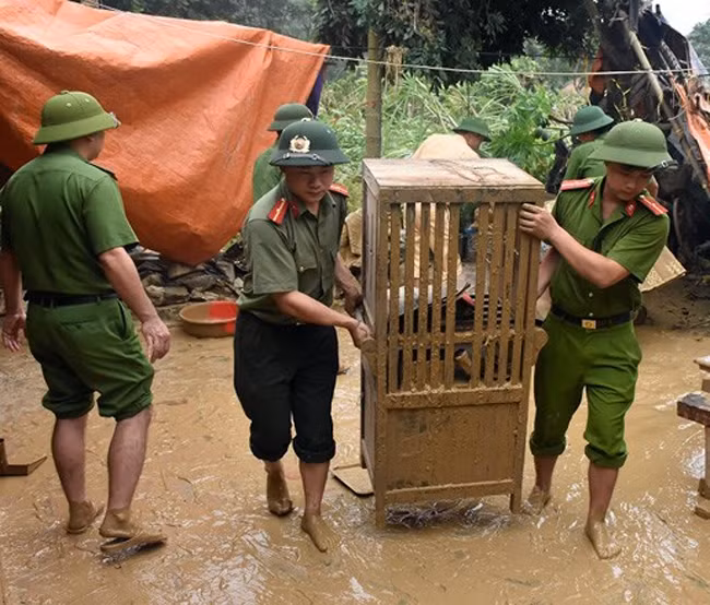 Cán bộ, chiến sĩ Công an huyện Thường Xuân giúp dân sửa sang nhà cửa, dọn dẹp vệ sinh sau lũ.