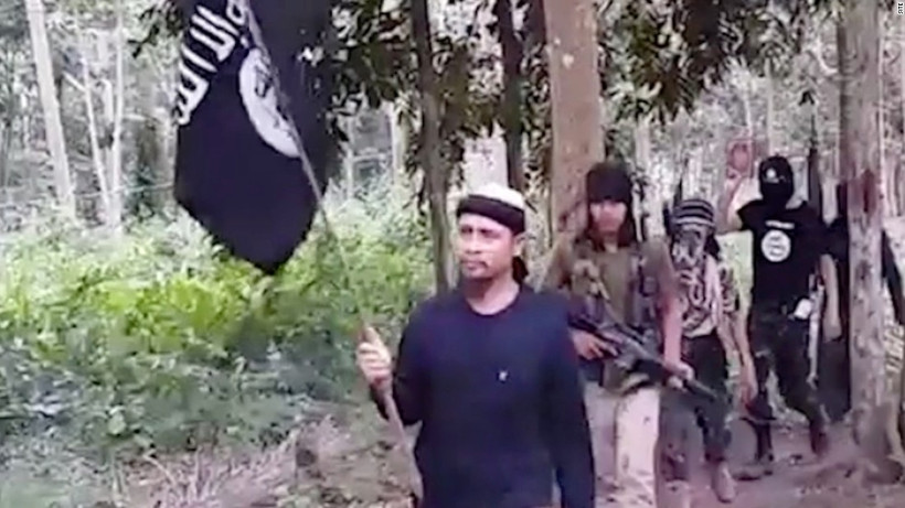 Thủ lĩnh nhóm Abu Sayyaf Isnilon Hapilon với lá cờ IS. (Ảnh: CNN)