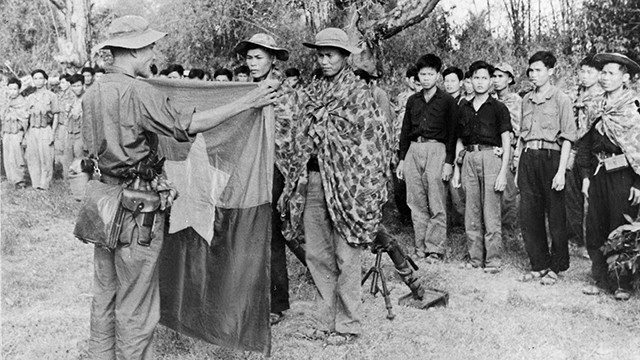 Ban Chỉ huy đơn vị X quân Giải phóng nhận cờ và mệnh lệnh chiến đấu trước giờ xuất kích. Ảnh tư liệu