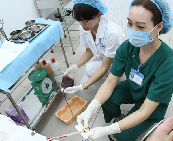 Các điều dưỡng đang tiến hành lấy mẫu máu dây rốn sau khi sản phụ vừa sinh xong. (Ảnh: VHH-TMT.Ư)