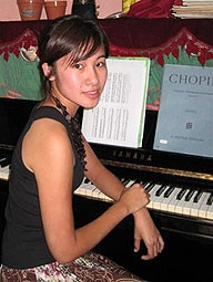 Vân Anh trong lúc<br>tập đàn tại Việt Nam.