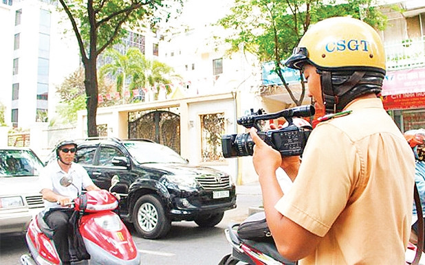 Cảnh sát giao thông đang ghi hình trên đường phố làm chứng cứ phạt nguội người vi phạm.