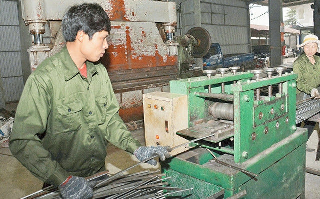 Công nhân doanh nghiệp cơ khí Năm Lan (xã Phùng Xá, huyện Thạch Thất) trong giờ sản xuất.