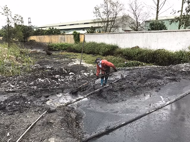 Bãi bùn do cơ sở tái chế nhựa xả thẳng ra bên ngoài cụm công nghiệp Tân Hồng (huyện Bình Giang, Hải Dương).