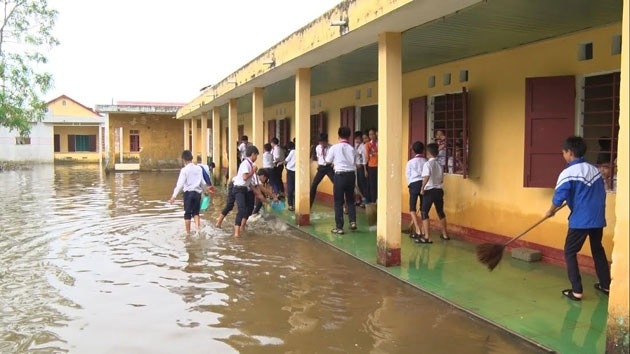 Các em học sinh Trường THCS Hội Yên, xã Hải Quế, huyện Hải Lăng (Quảng Trị) dọn dẹp vệ sinh sau lũ.
