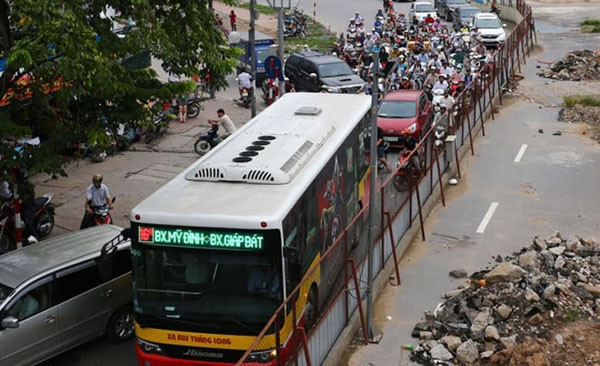 Xe buýt vất vả đi qua tuyến đường Xuân Thủy đang thi công tuyến đường sắt đô thị Nhổn-ga Hà Nội. Ảnh: DUY LINH