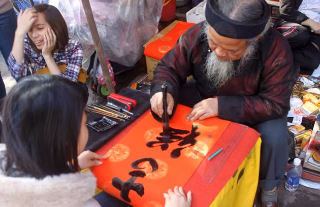 Thầy đồ Vũ Ngọc Kỳ thong thả thảo từng con chữ cho người xin chữ.