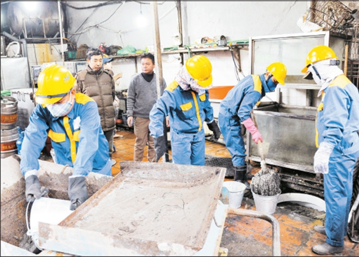 Công nhân Công ty Thoát nước Hà Nội tiến hành thu gom dầu mỡ thải trong thiết bị tách, được lắp đặt trước đó tại Nhà hàng Bảo Vân, số 658 phố Trương Định (quận Hoàng Mai, Hà Nội). Ảnh: ĐĂNG ANH