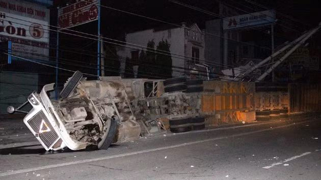 Xe container bị lật và nằm trên lề đường.