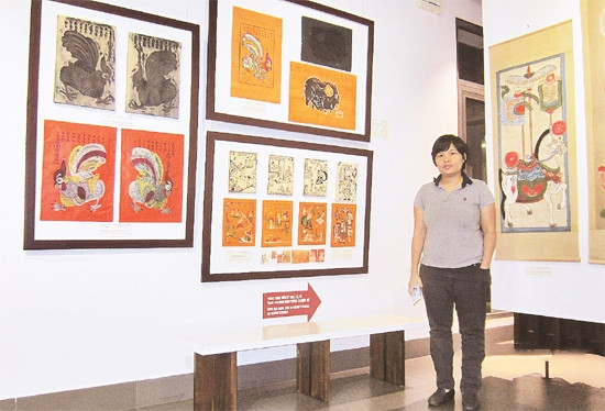 Chị Nguyễn Thị Thu Hòa bên những bức tranh Kim Hoàng mới được khôi phục.