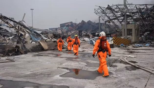 Các lính cứu hỏa được trang bị quần áo bảo hộ làm việc tại khu vực trung tâm xảy ra các vụ nổ ở Thiên Tân, Trung Quốc, ngày 15-8-2015. (Ảnh: Xinhua).