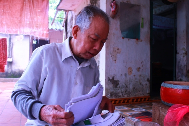 Ông Nguyễn Hữu Bổn tranh thủ tìm lại những bài giảng có các làn điệu Trống quân đã được ông ghi chép cẩn thận.