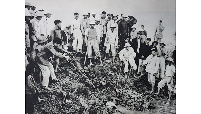 Chủ tịch Hồ Chí Minh tát nước chống hạn với bà con nông dân ở cánh đồng Quai Chải, xã Đại Thanh, huyện Thường Tín, Hà Đông (ngày 12-1-1958). Ảnh tư liệu