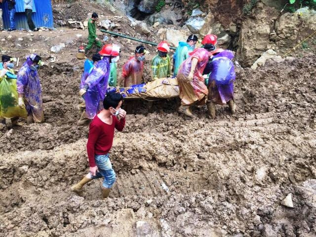 Lực lượng cứu hộ cứu nạn đưa thi thể nạn nhân ra ngoài hang.