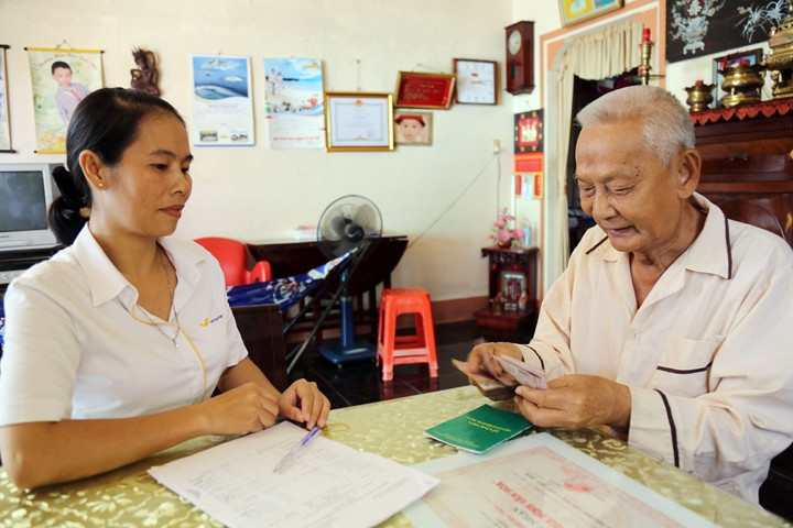 Người lao động được chi trả lương hưu hằng tháng tại nhà. Ảnh: TRẦN ĐỨC