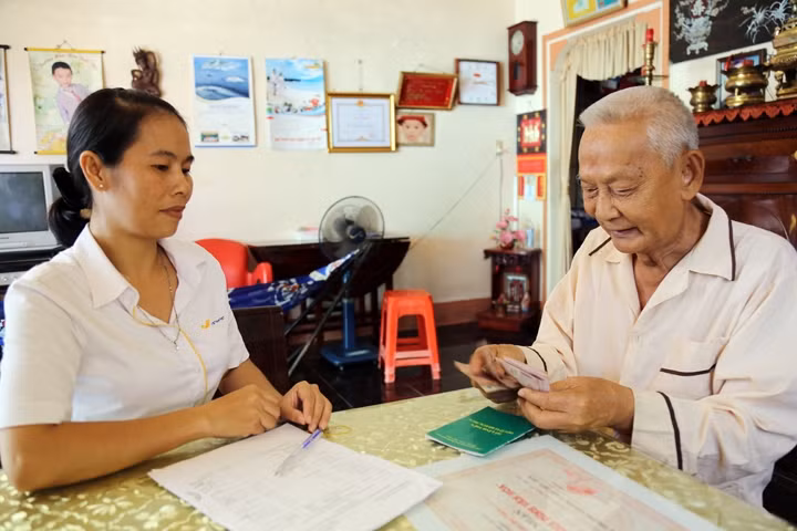 Người lao động được chi trả lương hưu hằng tháng tại nhà. Ảnh: TRẦN ĐỨC