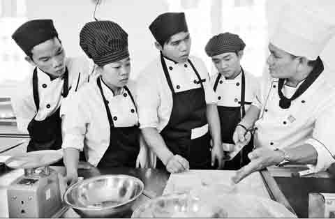 Các học viên có hoàn cảnh đặc biệt khó khăn trong giờ thực hành nấu ăn tại Trung tâm dạy nghề KOTO (cơ sở TP Hồ Chí Minh). Ảnh: S.Hickman