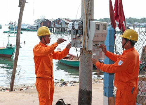 Công nhân Công ty Điện lực Kiên Giang (Tổng công ty Điện lực miền Nam) lắp đặt đồng hồ đo điện, cấp điện cho các hộ dân xã Gành Dầu, huyện đảo Phú Quốc. Ảnh: NGỌC HÀ