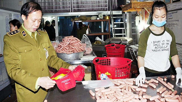 Lực lượng chức năng kiểm tra một cơ sở chế biến thực phẩm tại Hà Nội. Ảnh: HOÀI NAM