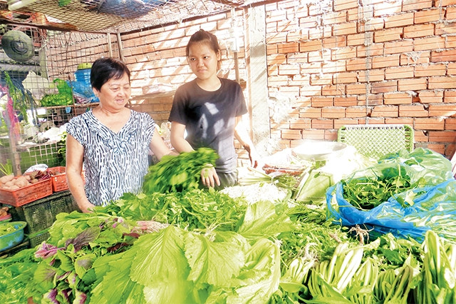 Bà Võ Thị Kính (người bên trái) trò chuyện với một hộ kinh doanh.