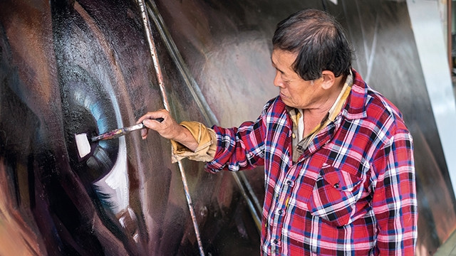 Ông Yan Jhen-Fa vẽ áp-phích cho một bộ phim. Ảnh: NSPP