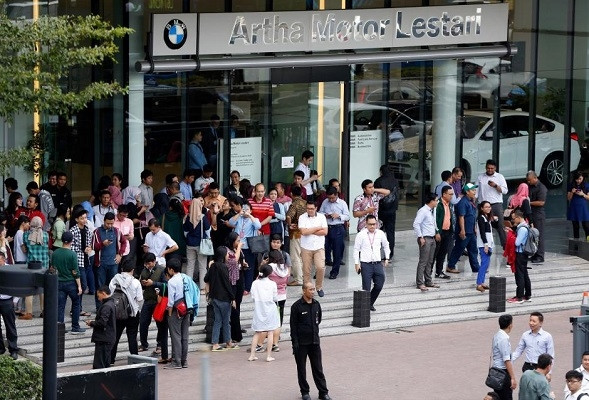 Các nhân viên công sở rời khỏi một tòa nhà sau trận động đất tại Jakarta, Indonesia, ngày 23-1-2018. (Ảnh: Reuters)