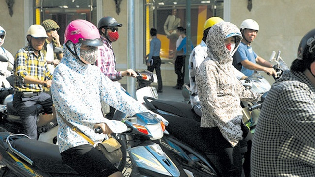 Khi nắng nóng cần uống nhiều nước, mặc quần áo rộng, nhẹ và sáng màu, đội mũ kết hợp với sử dụng kem chống nắng để phòng tránh say nắng. Ảnh: TM