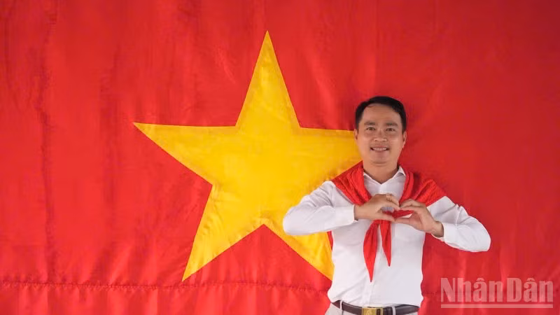Tiến sĩ Võ Văn Sơn, giảng viên trẻ của Trường đại học Tiền Giang chụp ảnh cùng cờ Tổ quốc.
