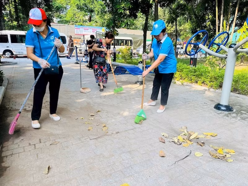 Người dân tham gia dọn dẹp vườn hoa Trần Quang Diệu sau một thời gian bị xuống cấp. 