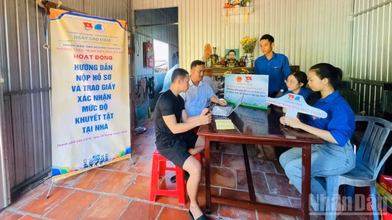 Đoàn viên, thanh niên tình nguyện hướng dẫn người dân nộp hồ sơ và trao giấy xác nhận mức độ khuyết tật tại nhà ở phường Cao Lãnh (tỉnh Đồng Tháp).