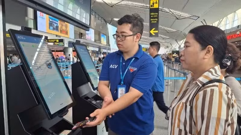 Người dân được hỗ trợ tại khu vực thực hiện sinh trắc học để lên tàu bay.
