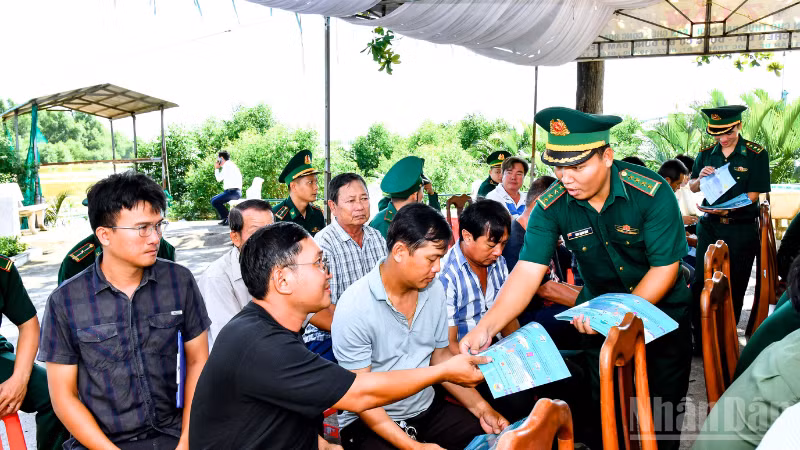 Cán Bộ đồn Biên phòng Trung Bình cấp phát tờ rơi tuyên truyền chống khai thác IUU cho bà con ngư dân tham dự lễ ra quân.