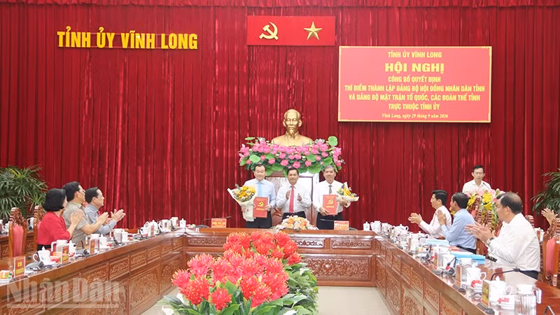 Đại diện các Đảng bộ Hội đồng nhân dân, Mặt trận Tổ quốc, các đoàn thể tỉnh Vĩnh Long nhận quyết định tại hội nghị. (Ảnh: MINH KHỞI)