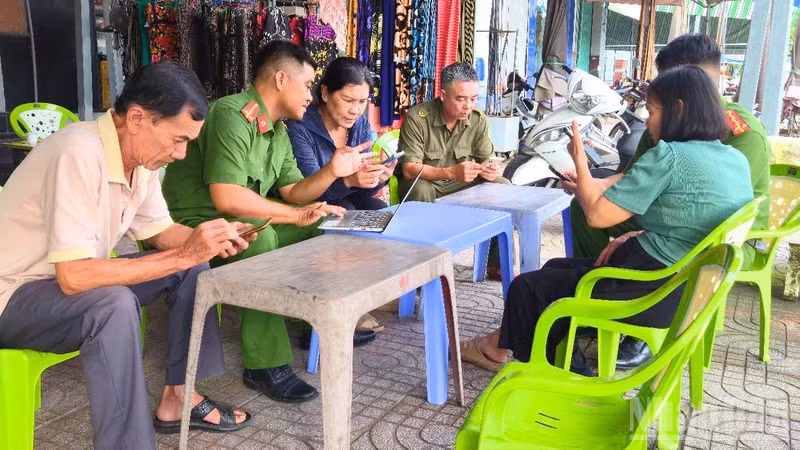 Cán bộ, chiến sĩ Công an phường Vị Thanh giải quyết thủ tục hành chính cho nhân dân tại cơ sở. (Ảnh: VĂN ÚT)